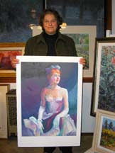 Photo of artist Diane Wallace holding one of her paintings